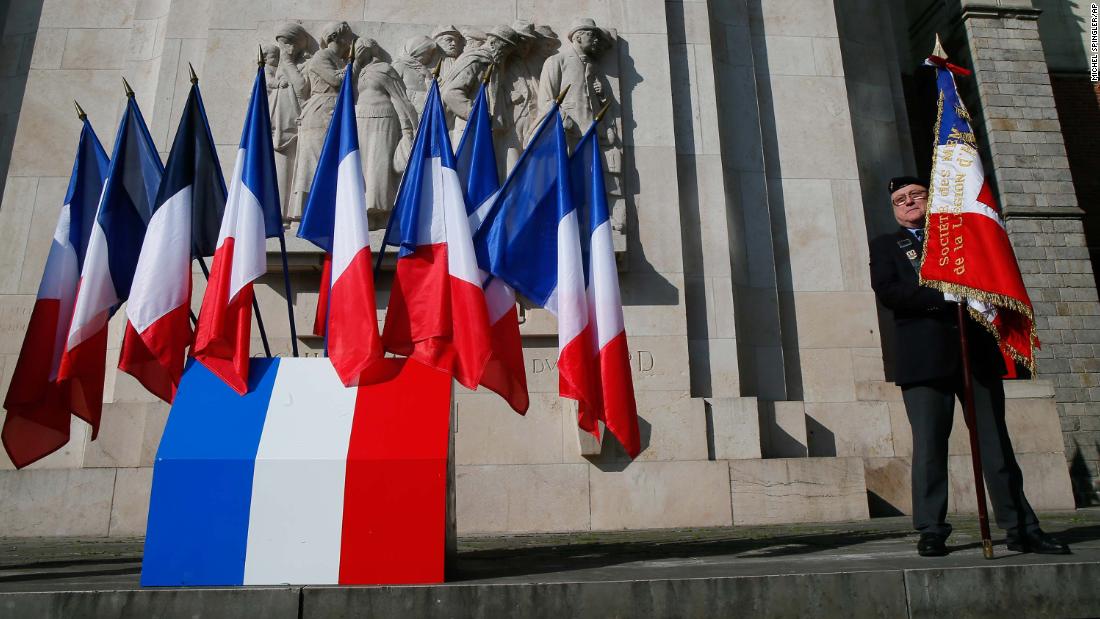 A veteran holds a French flag before a ceremony in Lille, France.