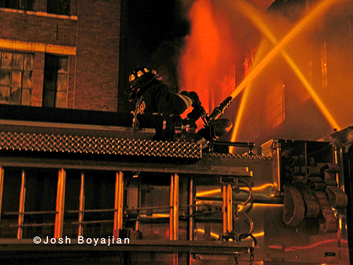 firefighter putting water onto huge fire