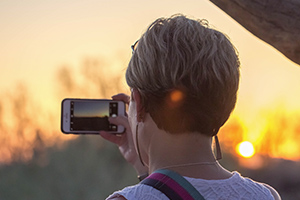 Guest taking sunset photo with cellphone