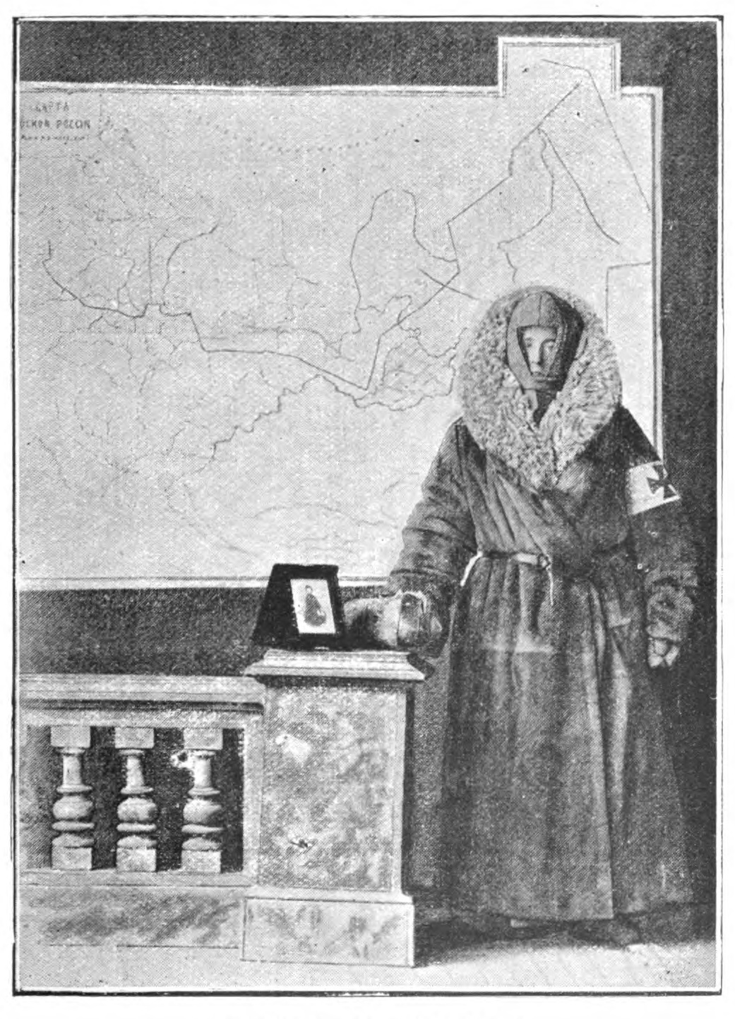 womwn in heavy coat, dress and hood, standing to the right of a map