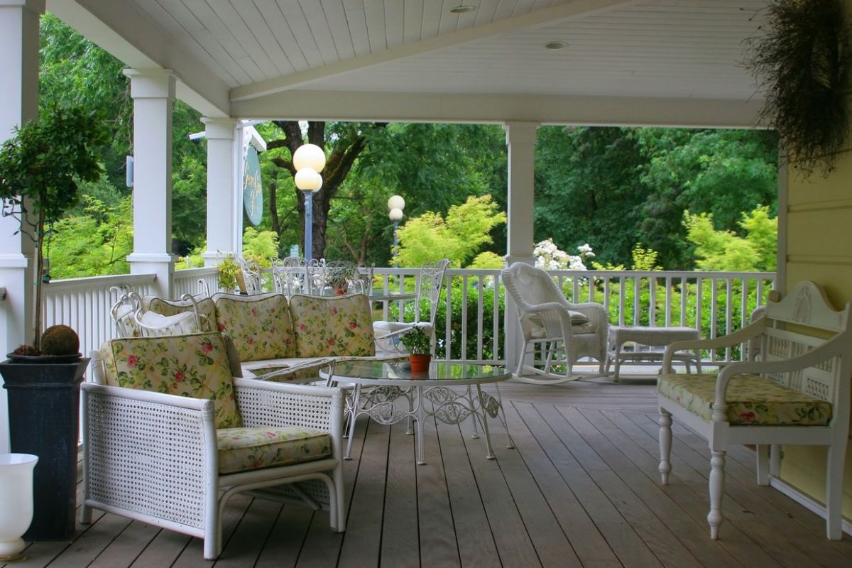 Cape cod style deck with wicker and wooden furniture