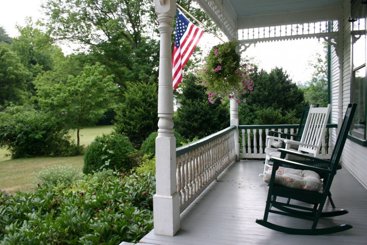 Classic New England porch with rocking chairs and a view of yard