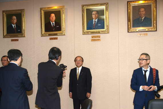 代々議長額の下で、記者の撮影に応じる