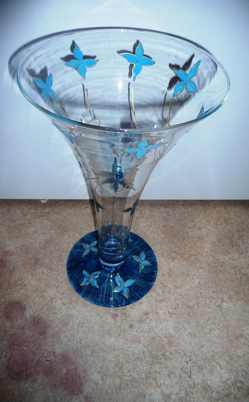 Vase en verre avec fleurs bleues