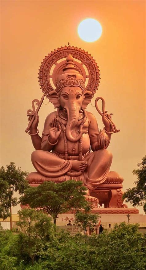 an elephant statue is shown with the sun in the background and trees ...