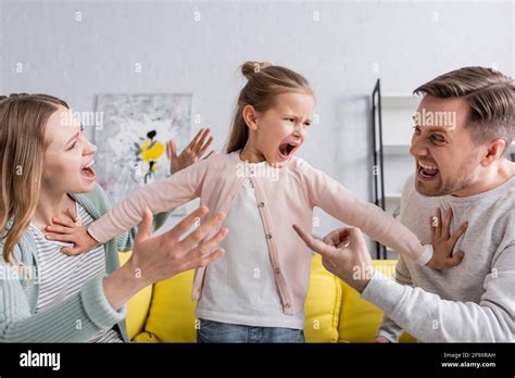 Yelling child pushing away quarreling parents Stock Photo - Alamy