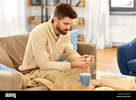 sick man measuring temperature by thermometer Stock Photo - Alamy