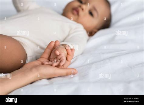 Cute little African American baby holding hands with mom Stock Photo - Alamy