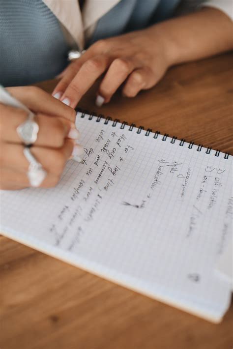 Close-Up View of a Person Writing Notes on a Notebook · Free Stock Photo