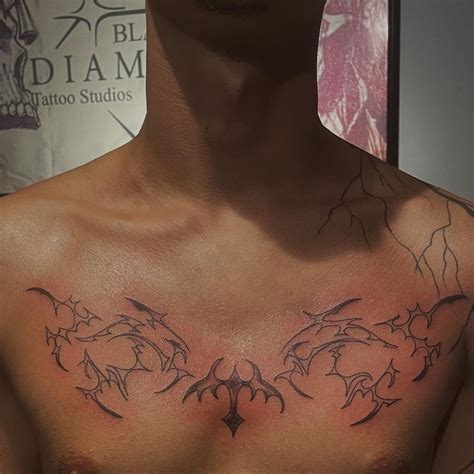 a man's chest with tattoos on it