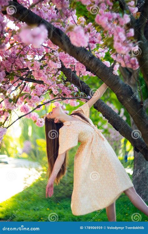 Fashion Photo of Beautiful Woman with Dark Hair Posing in Blossom Spring Garden. Cherry Blossom ...