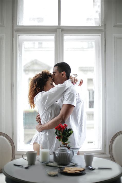 Couple Hugging And Kissing While Standing Near Window At Home · Free ...