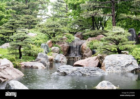 A waterfall drops into a pond in a Japanese garden Stock Photo - Alamy