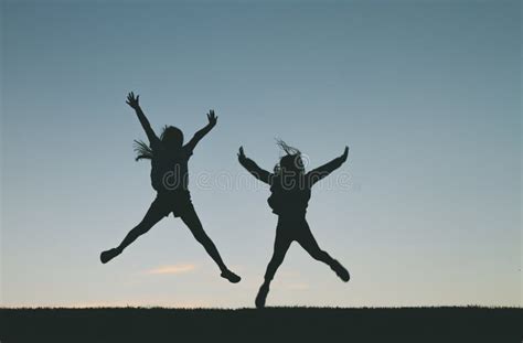 Children Jumping at Sunset Silhouette Stock Photo - Image of outdoors ...