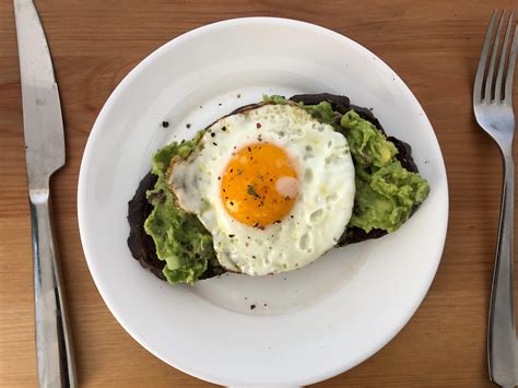 [Homemade] Sunnyside up egg with guacamole on pumpernickel toast : r/food