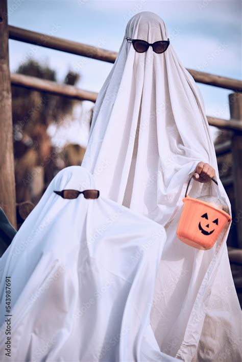 Halloween, friends and ghost costume for fun, festival and celebration while bonding at park ...