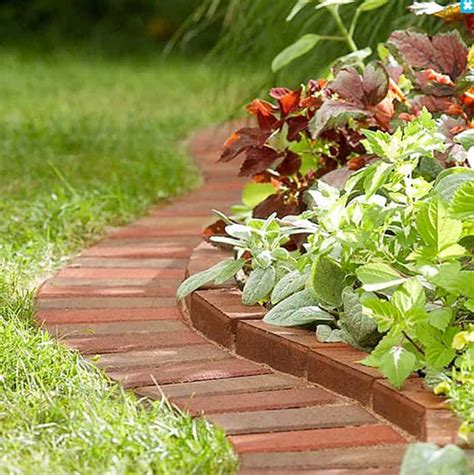 a brick garden border with green and red plants