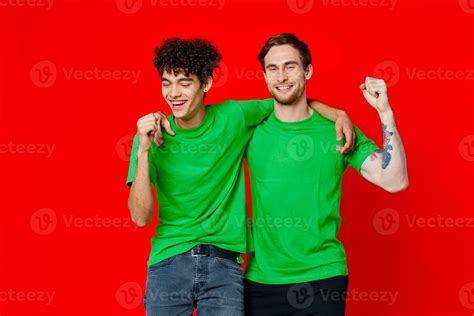 funny friends green t-shirts hugs emotions joy red background 23729713 Stock Photo at Vecteezy