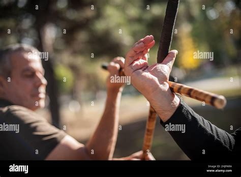 Escrima and kapap instructor demonstrates sticks fighting techniques and training methods in ...