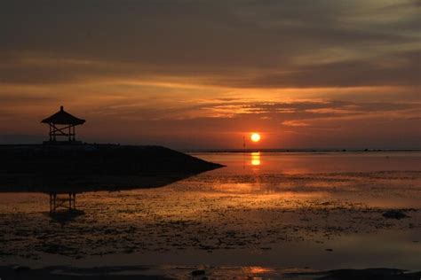 Premium Photo | Sunrise shining on the beach and gazebo at pantai karang sanur bali indonesia