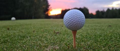 Premium Photo | Closeup of golf ball on a tee and sunset or sunrise