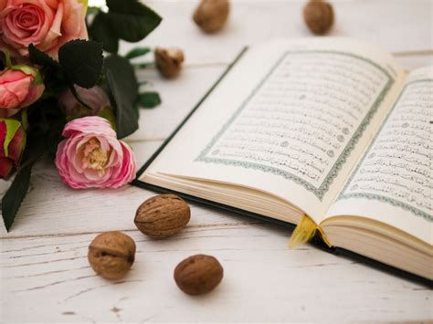 Opened quran next to pink roses Photo | Free Download