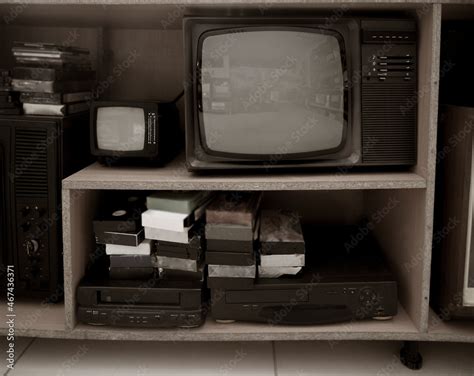 Old video recorder and tv . Vintage Video VHS Player on the shelf. VHS cassette and DVD disc ...