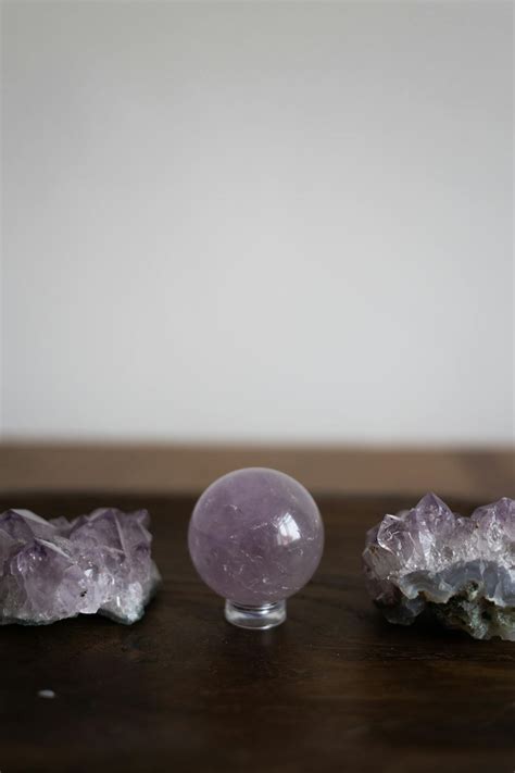 A Crystal Ball Between Gemstones on a Wooden Table · Free Stock Photo