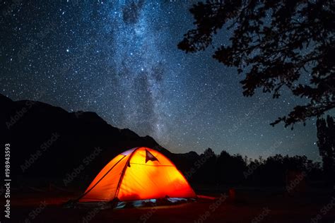 Tent and night sky. Highlighted orange hiking tent and deep starry sky ...