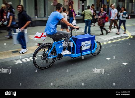 CitySprint Courier London - a Citysprint Courier on a cargo bike races down Oxford Street in ...