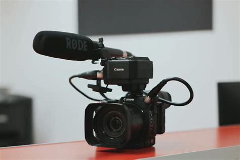 Black Canon Video Camera With Microphone on Desk · Free Stock Photo