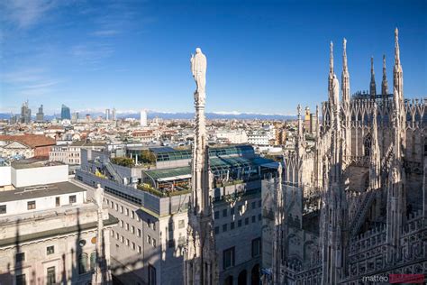 - Milan skyline from the top of the Duomo, with alps in the background | Royalty Free Image