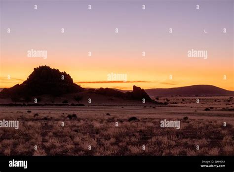 African sunset with mountains and grass plains and moon Stock Photo - Alamy