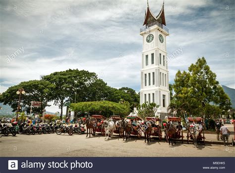 Famous clock tower of Bukittinggi, Jam Gadang in West Sumatra, Indonesia. Horse and carriages ...