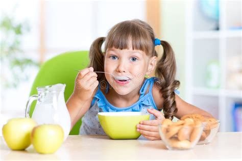 Cute Little Girl Eating Cereal with Milk in Stock Photo - Image of dish, childhood: 59026424