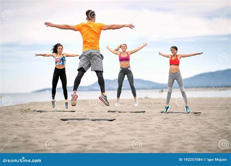 Fitness People Jumping and Fitness Workout on the Beach Stock Photo ...