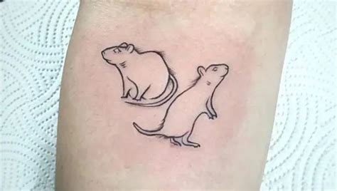 a small rat and mouse tattoo on the right arm, which is drawn in black ink