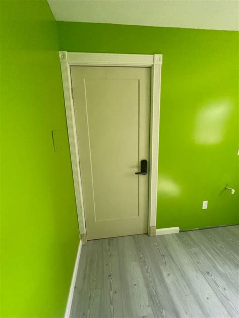 an empty room with green walls and white trim on the door is painted ...