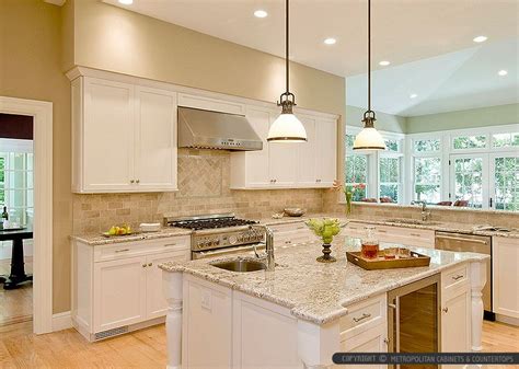 Bianco romano granite countertop beige kitchen cabinets with subway travertine backsplash tile ...