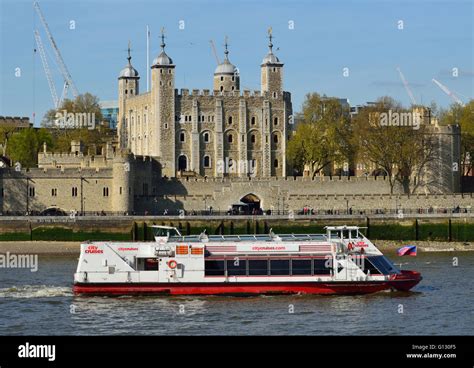 One of the City Cruises' London sightseeing boats on the river Thames passing the Tower of ...