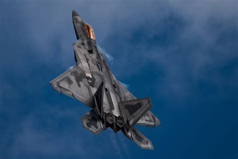 An F-22 Raptor aircraft performs a 'tail slide' maneuver during an ...