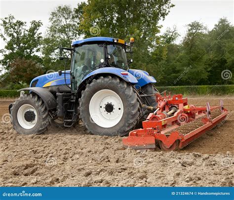 Blue Tractor Pulling Power Harrow Stock Images - Image: 21324674