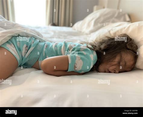 Little girl sleeping in white sheets with messy hair Stock Photo - Alamy