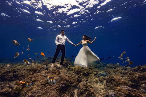 Bride and groom pose for underwater wedding shoot