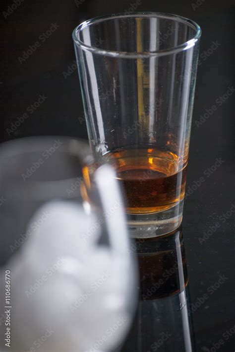 Whiskey Glass - Scotch Glass with ice cubes with background and shinny reflection on bottom ...