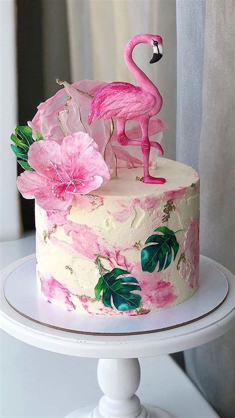 a pink flamingo cake sitting on top of a white table