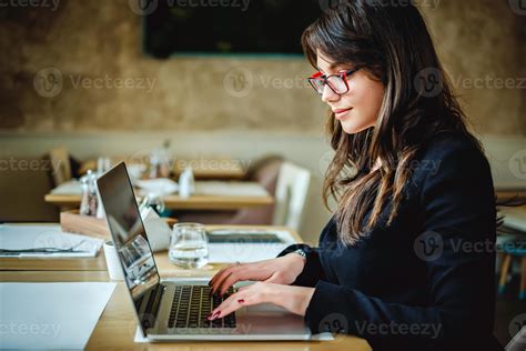 Happy girl typing on computer in restaurant 1175575 Stock Photo at Vecteezy