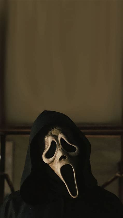 a person in a black hooded jacket with a ghost mask on