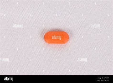 Orange oval pill isolated on white background Stock Photo - Alamy