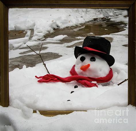 This framed image is a picturesque capture of a snowman melting as the ...